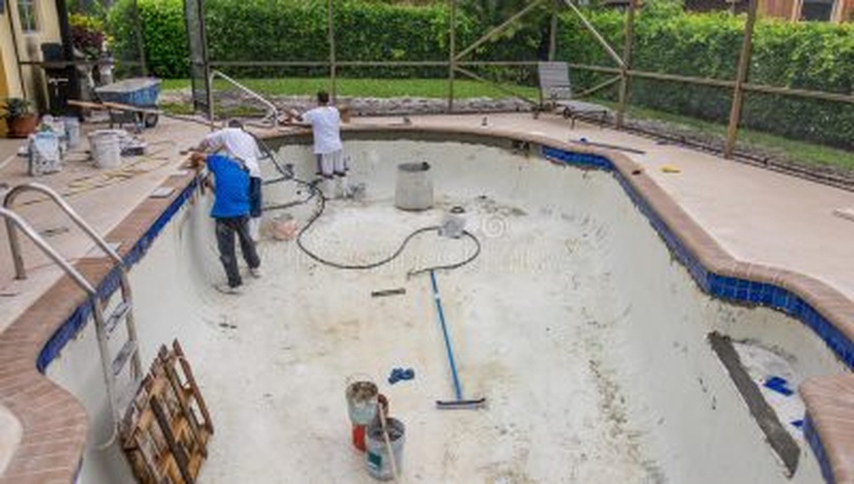 Workers Repairing and Resurfacing an Empty Residential Swimming Pool